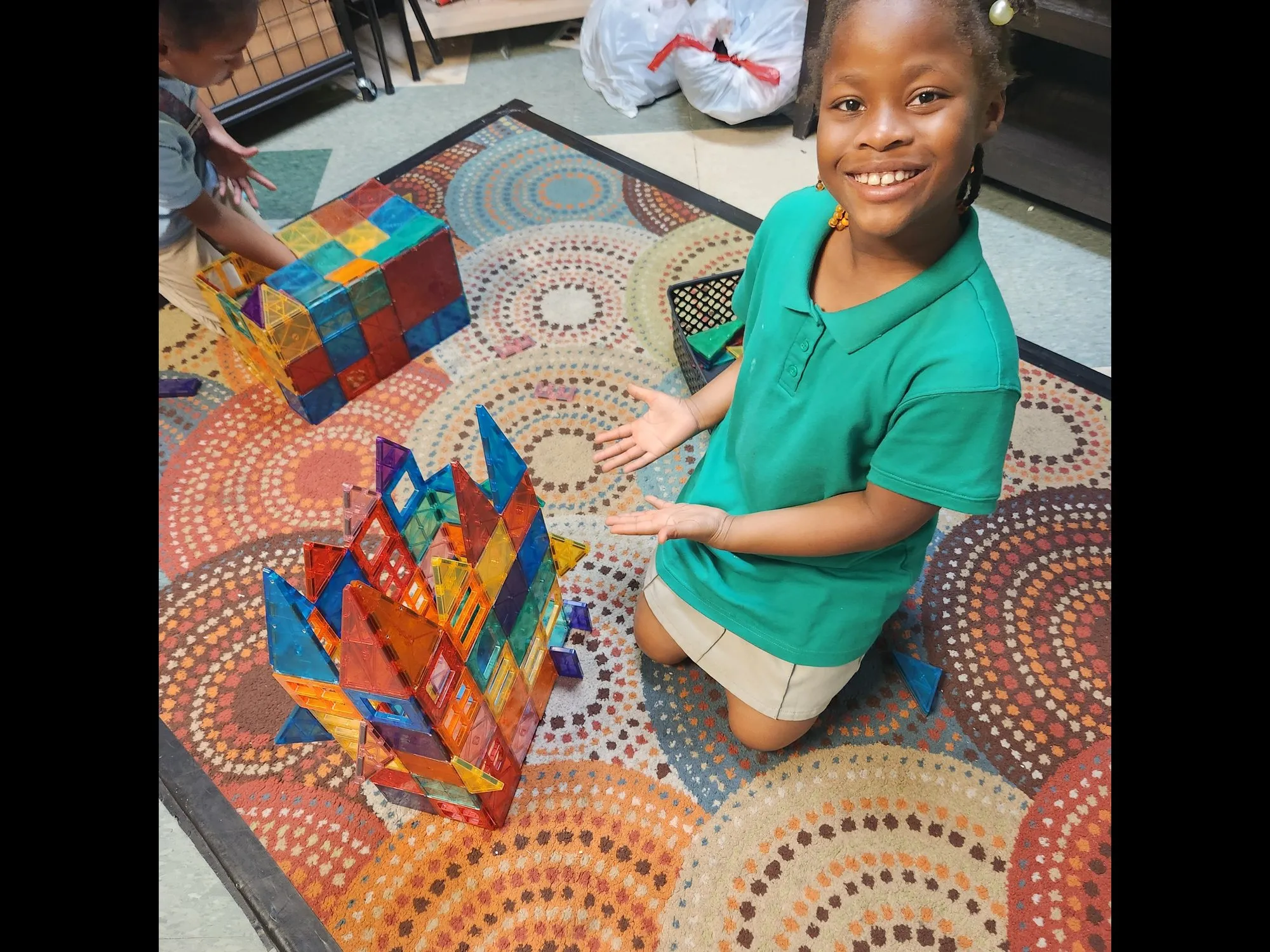 Smiling girl with a magnetic tile construction